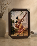 Framed Ravi Varma painting featuring a woman playing a musical instrument, elegant home decor