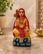 Adisankarar small statue in vibrant colors, placed on a table surrounded by decor items.