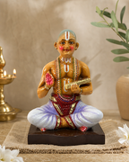 Colorful Desigar statue seated on a decorative base, adorned with traditional attire.