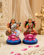 Beautifully crafted figurines of Lakshmi and Saraswathi on lotus seats, vibrant colors, ideal for decor