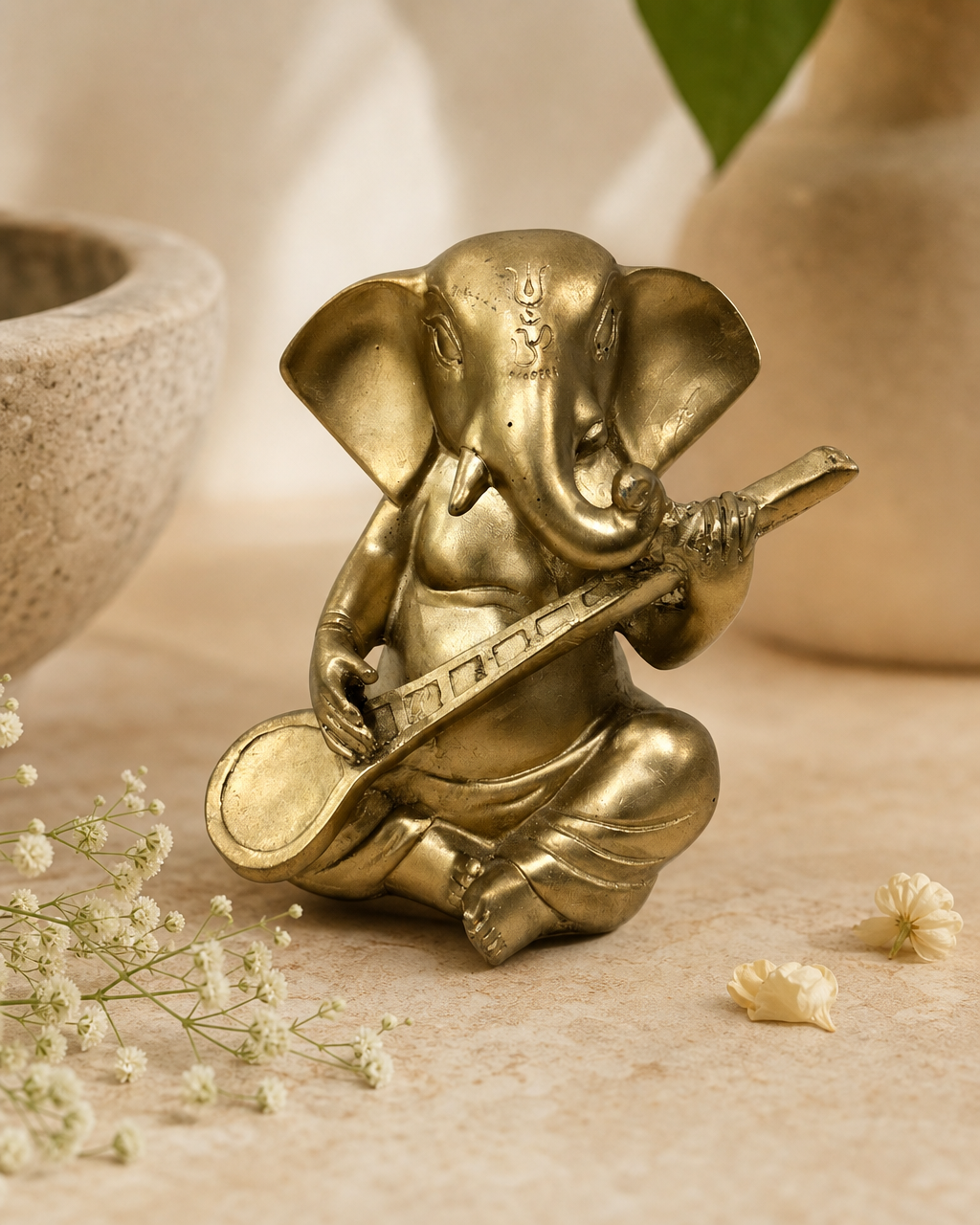 Guitar Ganesh figurine with detailed craftsmanship, featuring an elephant-headed deity playing a guitar, set on a textured surface.