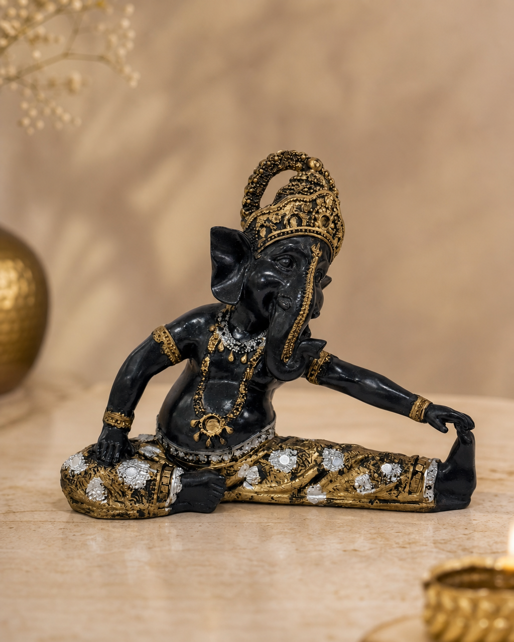 Elegant Ganesh figurine in a leg stretch pose with intricate gold detailing.