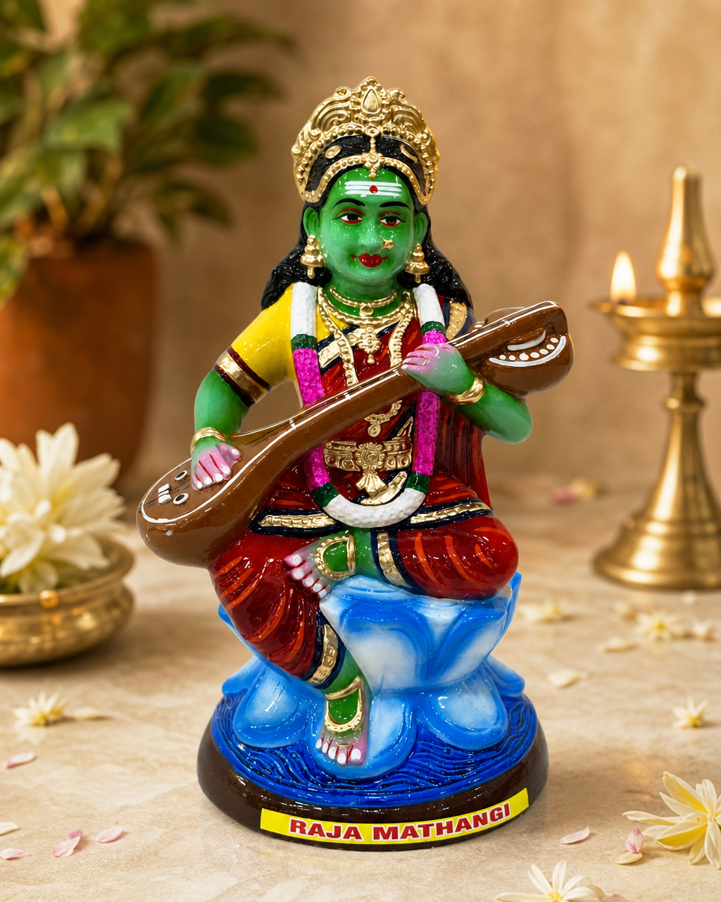 Colorful Raja Mathangi figure seated with a musical instrument, surrounded by flowers and traditional decor.