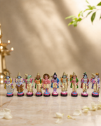 Ten colorful Dhasavatharam figurines displayed on a marble surface with soft lighting and a blurred background.