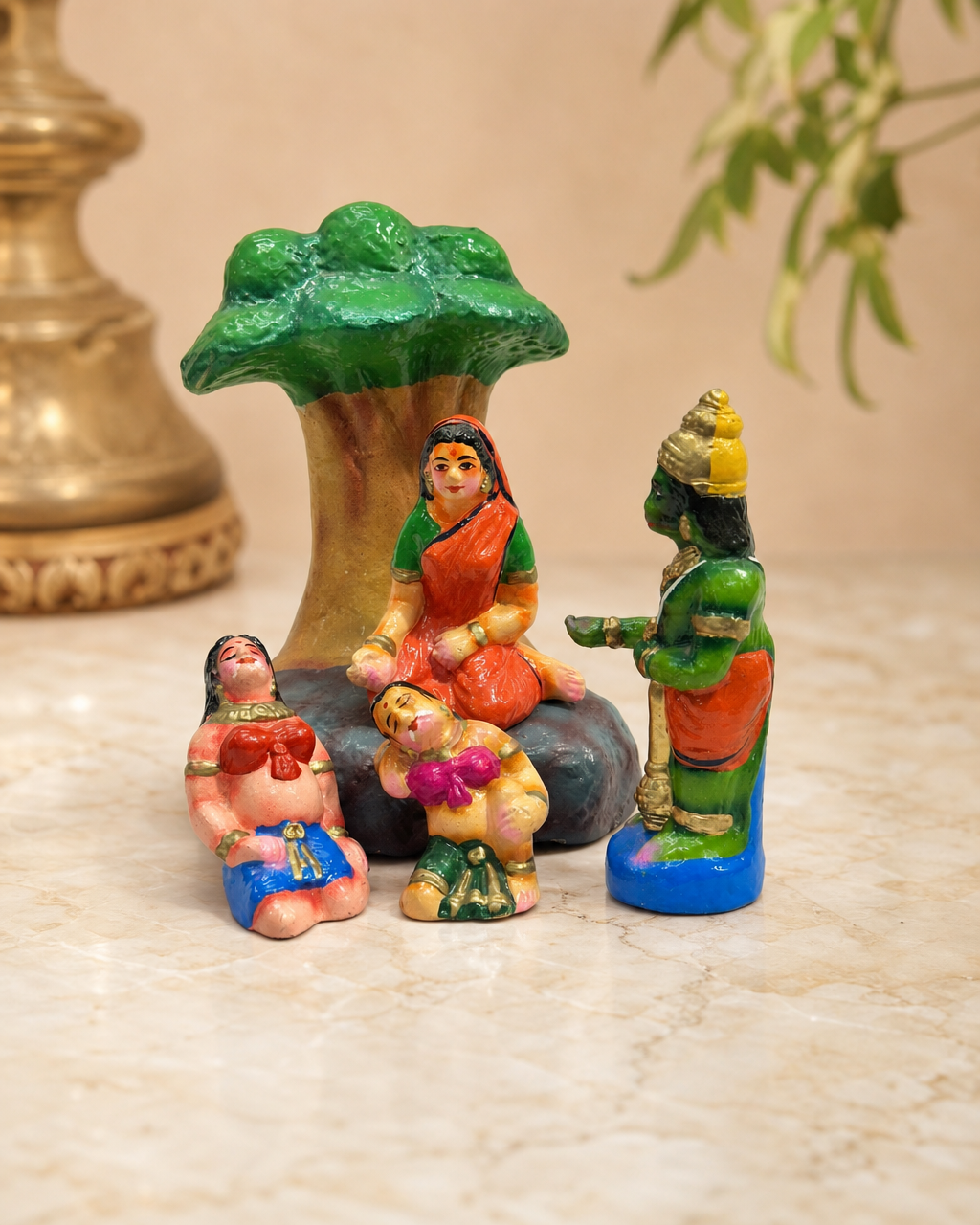 Kanaiyali figurine set with a tree and painted figures on a marble surface