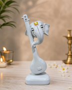 Elephant Veena Sculpture placed on a table with candles and flowers in the background
