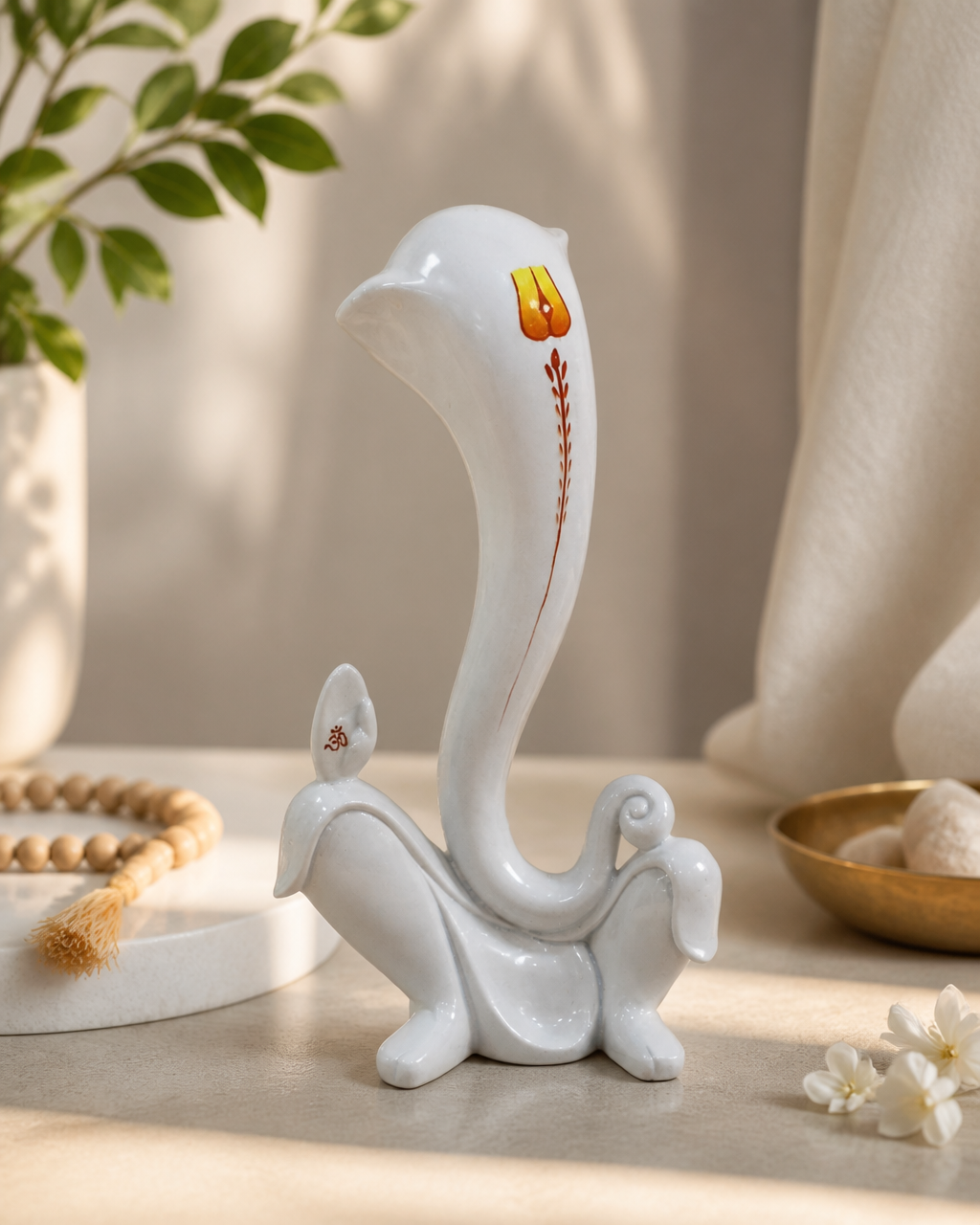 Elegant decorative figurine, white with painted design, 11 inches tall, displayed on a table with beads and flowers.