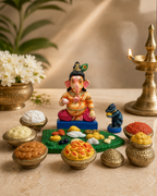 Colorful Vinayagar with traditional sapadu set and decorative items.