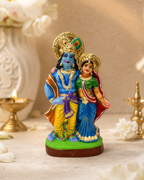 Colorful statue of Radha and Krishna standing together with intricate details.