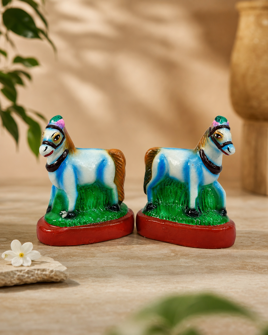 Pair of colorful Jodi Kuthirai statues on a decorative surface.