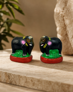 A pair of colorful Jodi Yaanai elephant figurines with intricate details displayed on a stone surface.