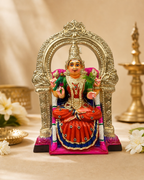 Colorful Kamakshi deity idol with intricate designs, seated with ornaments, set in a temple-like arch with a golden finish.