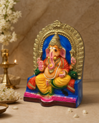 Colorful Raja Ganapathy idol seated in an ornate arch, surrounded by decor and flowers.