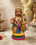 Colorful Urkantha Hanuman statue on marble surface with decorative background