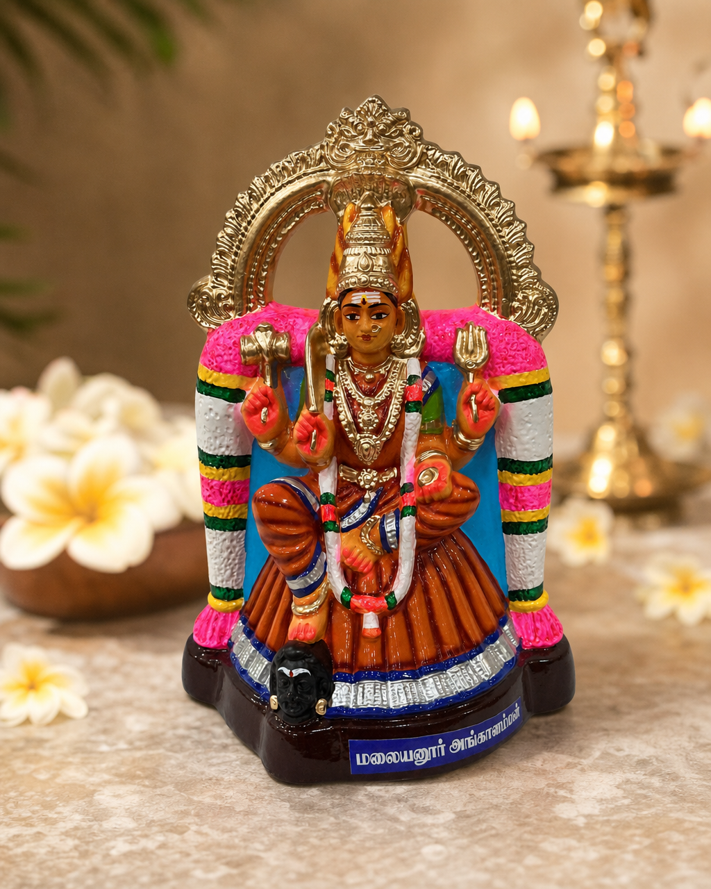 Colorful Malayanoor Angal statue with intricate details and traditional design, surrounded by floral decor.