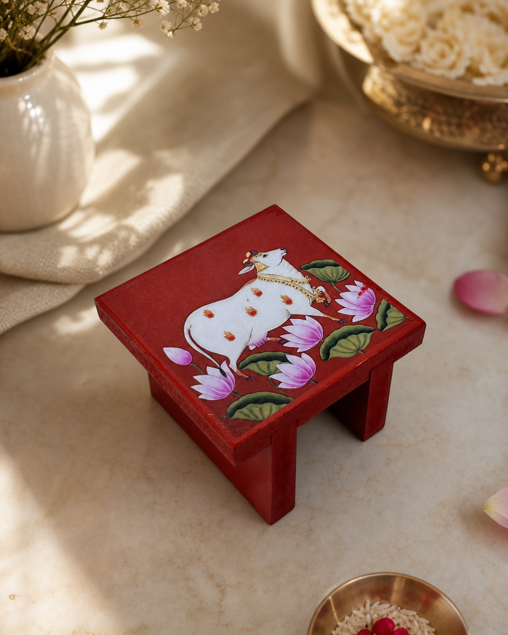 Handcrafted red decorative table with a painted cow and lotus design