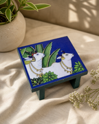 Decorative table with artistic design featuring cows and leaves.
