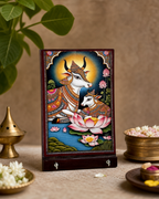 Decorative art panel featuring a colorful depiction of a cow and calf set against a lotus backdrop, surrounded by traditional artwork.
