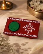Red and green Agarbathi stand with decorative white patterns