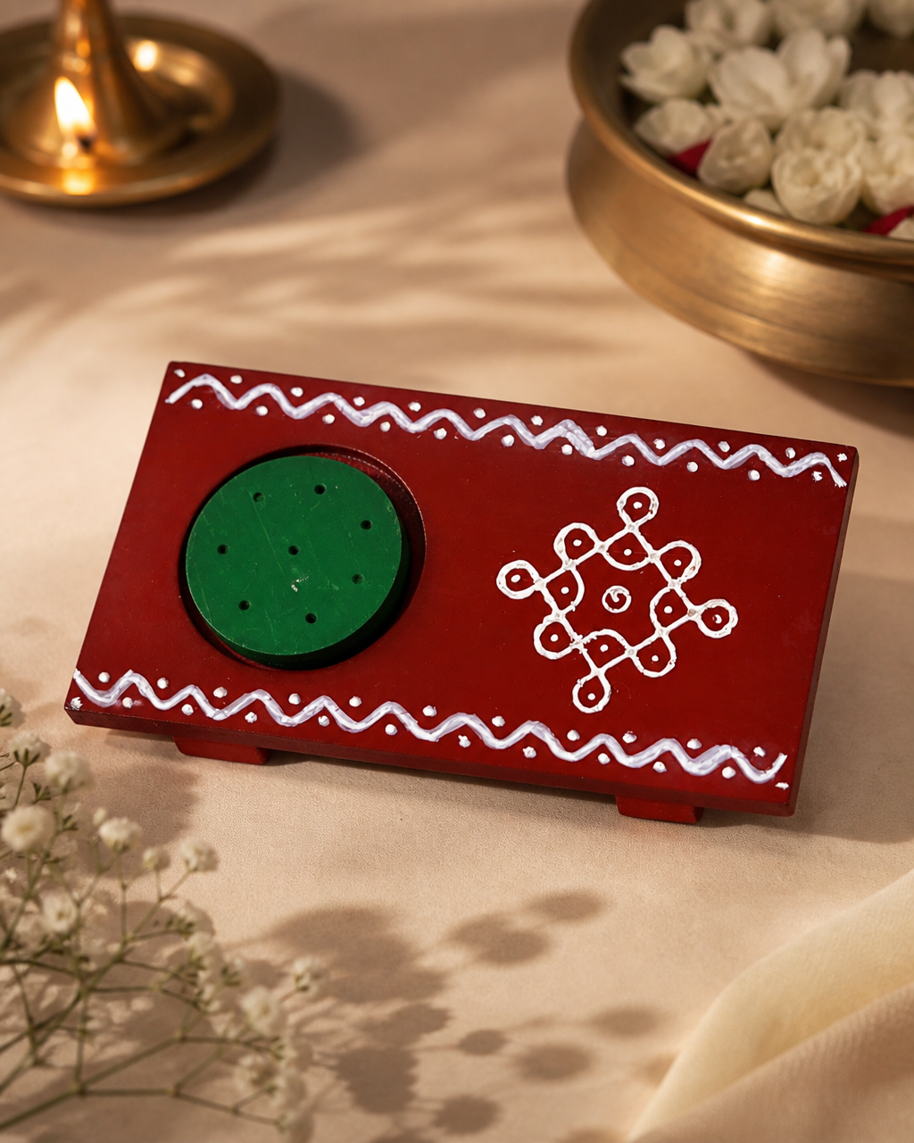 Red and green Agarbathi stand with decorative white patterns