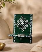 Elegant hanging Kolam art design with intricate patterns on a green background.