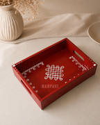Decorative red tray with handle and white designs on a neutral background