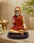 Jayendra figurine in seated position with serene expression, set on a decorative platform.